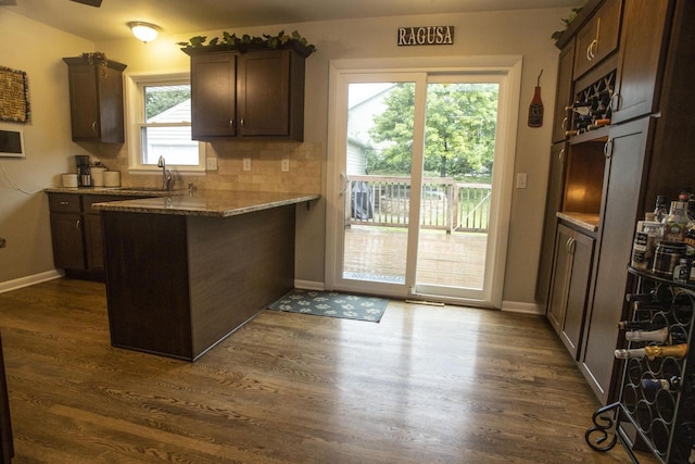2563 S 91st St, West Allis, WI 53227 - kitchen featuring a peninsula, dark wood-type flooring, dark brown cabinetry, and light stone counters