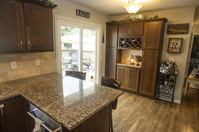 2563 S 91st St, West Allis, WI 53227 - kitchen featuring backsplash, light wood-style flooring, stone counters, and a peninsula