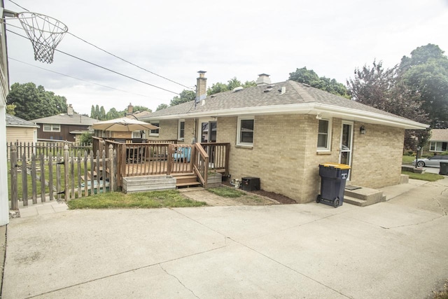 2563 S 91st St, West Allis, WI 53227 - back of property with a wooden deck, a chimney, brick siding, and a patio area