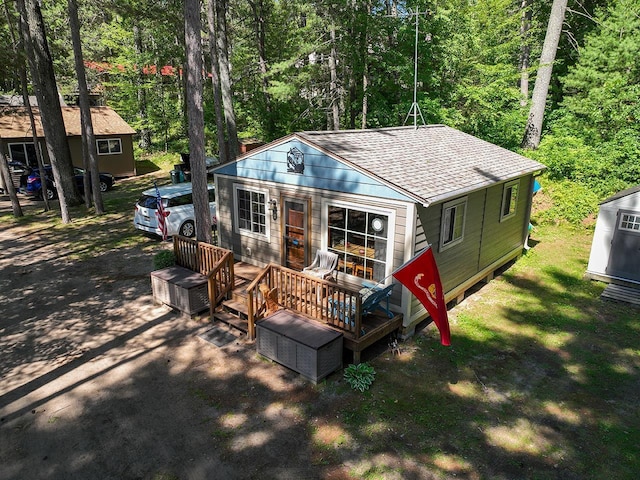 W6020 Northern Lights Cir Unit 7, Tomahawk, WI 54487 - back of property featuring a shingled roof, a wooden deck, and a wooded view