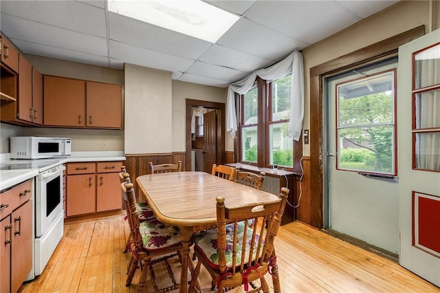 246 Coleman St, Chippewa Falls, WI 54729 - kitchen with white appliances, a wainscoted wall, a paneled ceiling, light countertops, and light wood-style flooring