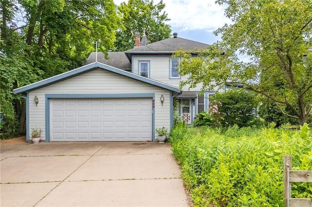 246 Coleman St, Chippewa Falls, WI 54729 - traditional home featuring an attached garage, concrete driveway, and a chimney