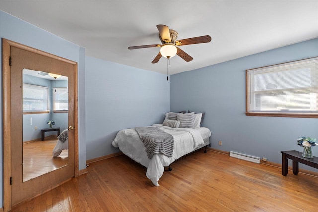 4683 N 80th St, Milwaukee, WI 53218 - bedroom with baseboard heating, light wood-type flooring, and ceiling fan