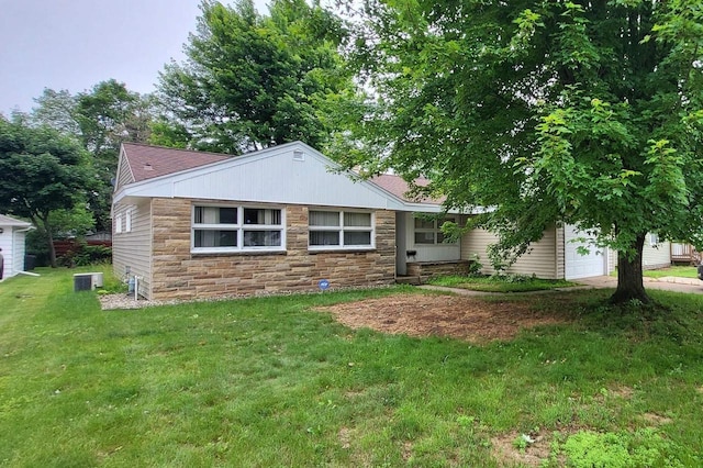 921 S 10th St, Wisconsin Rapids, WI 54494 - view of front of home with stone siding, a front yard, and a garage