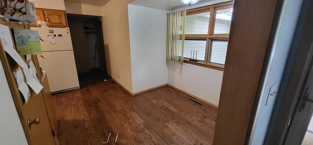 921 S 10th St, Wisconsin Rapids, WI 54494 - unfurnished dining area with dark wood-type flooring and baseboards