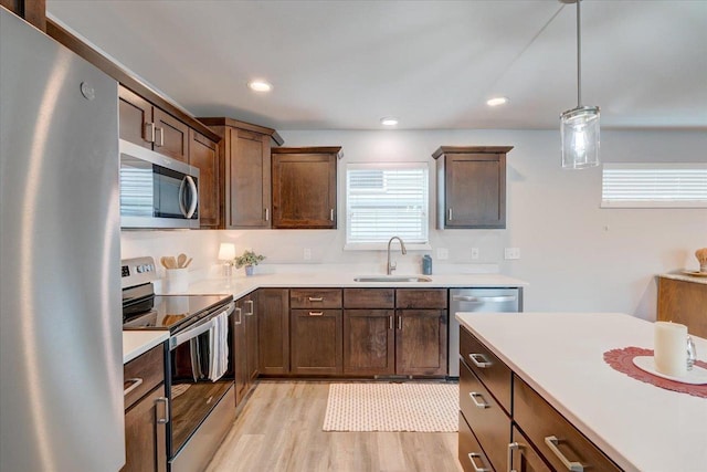 615 Prospect Rd, Waunakee, WI 53597 - kitchen featuring appliances with stainless steel finishes, light countertops, light wood finished floors, hanging light fixtures, and recessed lighting