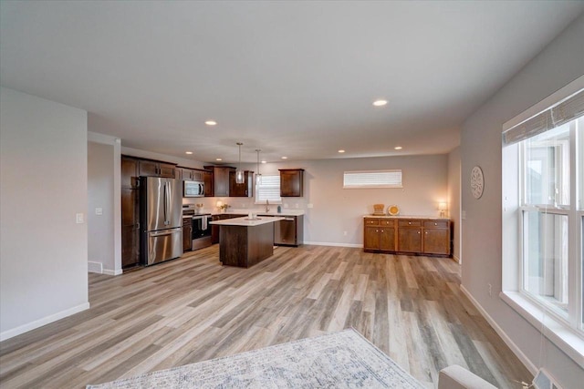 615 Prospect Rd, Waunakee, WI 53597 - kitchen featuring stainless steel appliances, light wood finished floors, a kitchen island, light countertops, and recessed lighting