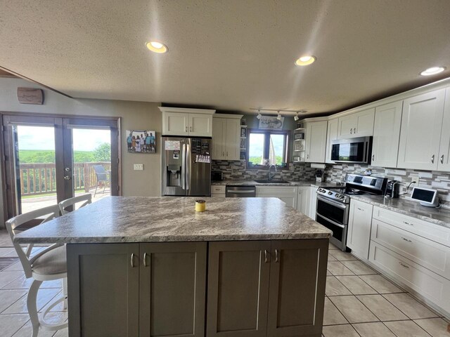 E3577 US Highway 14, Coon Valley, WI 54623 - kitchen with appliances with stainless steel finishes, a center island, tasteful backsplash, white cabinets, and recessed lighting
