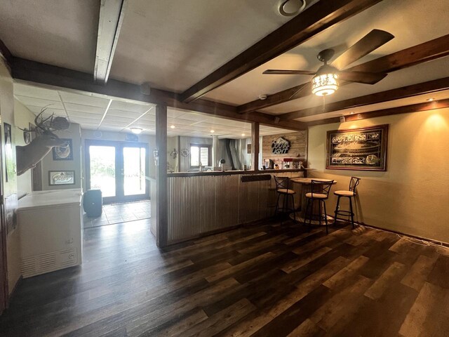 E3577 US Highway 14, Coon Valley, WI 54623 - kitchen featuring dark wood-style flooring, beam ceiling, ceiling fan, a peninsula, and a kitchen bar
