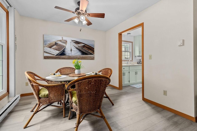 2360 Wisconsin St, Oshkosh, WI 54901 - dining area with baseboard heating, light wood finished floors, and ceiling fan