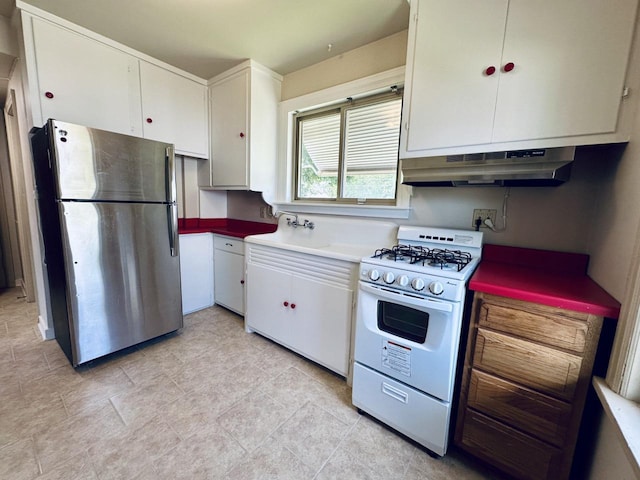 2377 S 76th St, West Allis, WI 53219 - kitchen with freestanding refrigerator, white gas stove, under cabinet range hood, and white cabinets