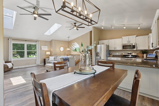5538 Galway Dr, Waunakee, WI 53597 - dining space featuring a skylight, ceiling fan, lofted ceiling, light wood-type flooring, and rail lighting
