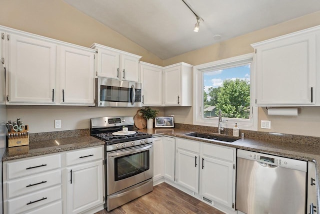 5538 Galway Dr, Waunakee, WI 53597 - kitchen with appliances with stainless steel finishes, white cabinetry, vaulted ceiling, dark wood finished floors, and dark stone countertops