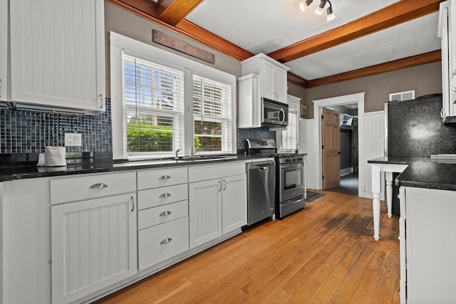 415 S Lake Shore Dr, Lake Geneva, WI 53147 - kitchen featuring stainless steel appliances, beam ceiling, decorative backsplash, light wood-style floors, and white cabinets