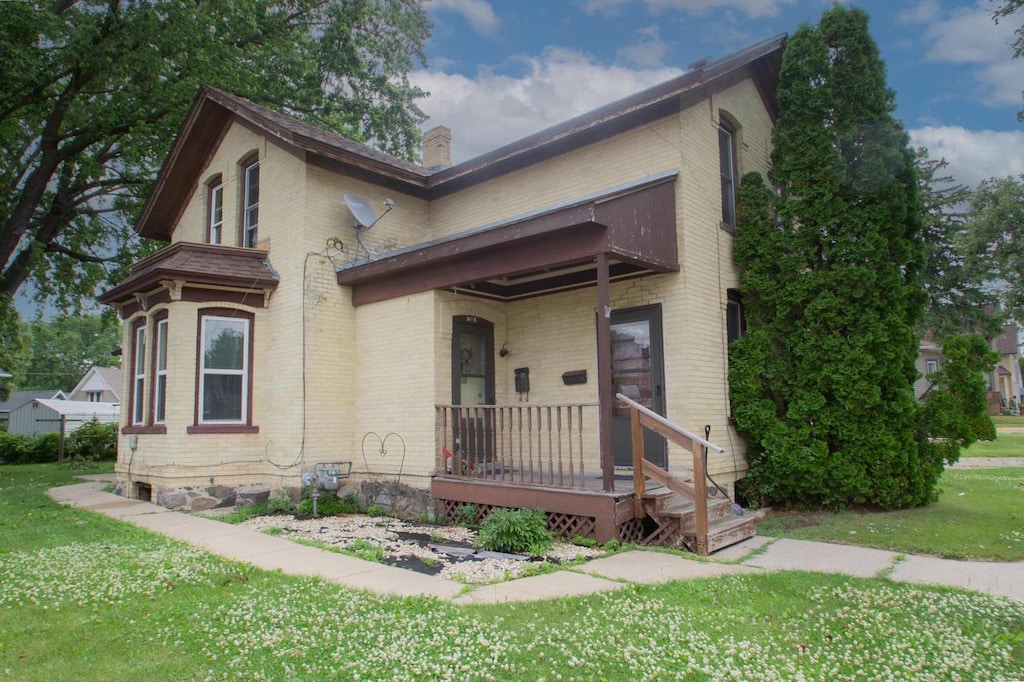 908 E Main St, Watertown, WI 53094 - view of front of home with brick siding, a chimney, and a front yard