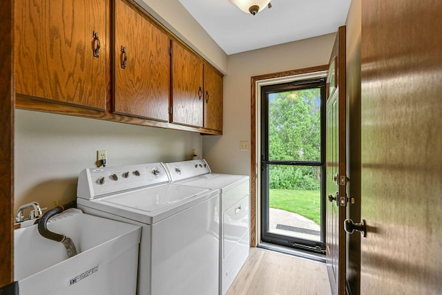 3948 S 72nd St, Milwaukee, WI 53220 - washroom with washing machine and dryer, cabinet space, and light wood-type flooring