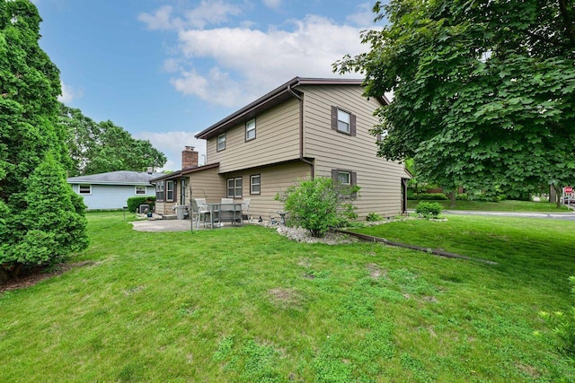 3948 S 72nd St, Milwaukee, WI 53220 - back of property with a patio, a yard, and a chimney