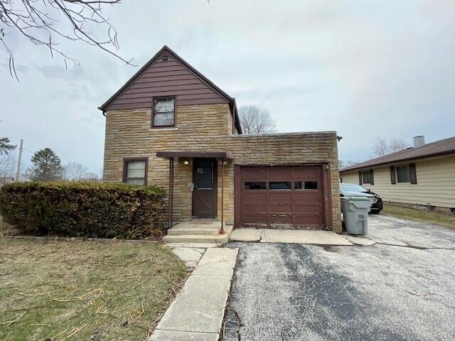 6352 N 104th St, Milwaukee, WI 53225 - view of front of house with stone siding, driveway, and a garage