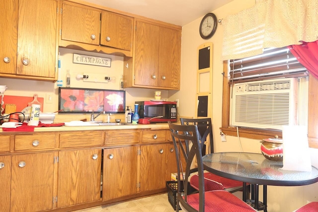8761 W Herbert Ave, Milwaukee, WI 53225 - kitchen with black microwave, light countertops, and brown cabinetry