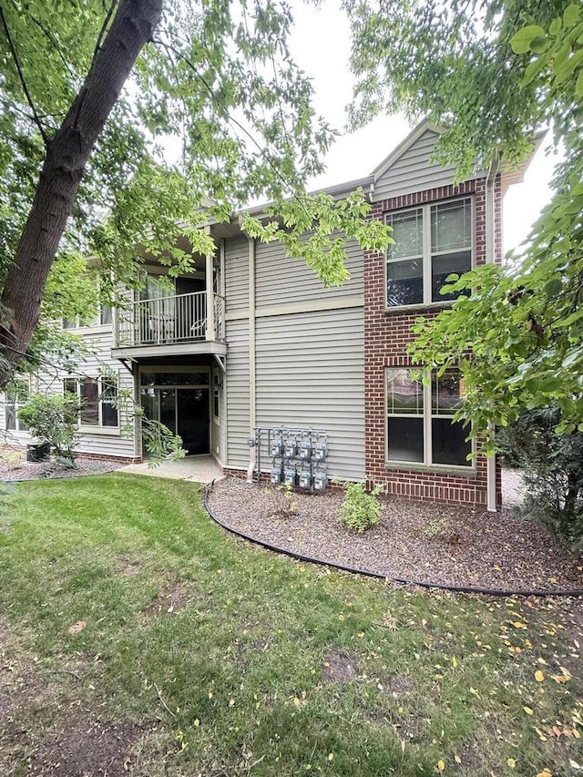 N82W13370 Fond Du Lac Ave Unit 101, Menomonee Falls, WI 53051 - rear view of house featuring a lawn, a balcony, and brick siding