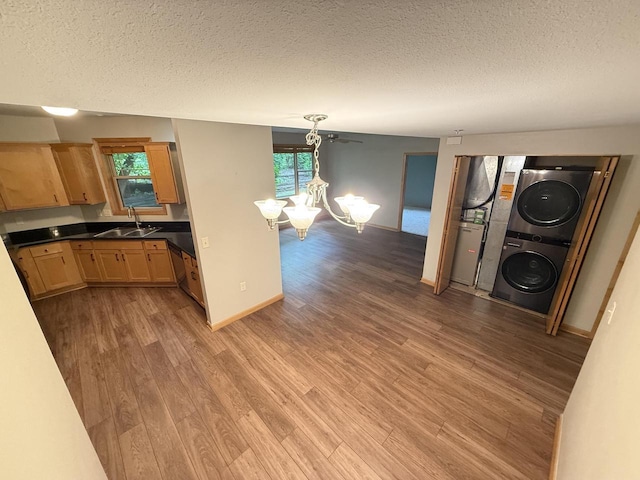 N82W13370 Fond Du Lac Ave Unit 101, Menomonee Falls, WI 53051 - kitchen featuring stacked washing machine and dryer, a textured ceiling, a chandelier, light wood-style flooring, and light brown cabinetry