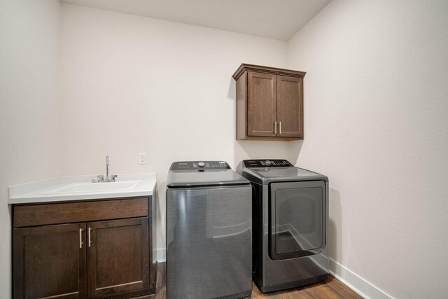 520 Meadow View Dr, Slinger, WI 53086 - laundry room with cabinet space, washing machine and dryer, and light wood-style flooring