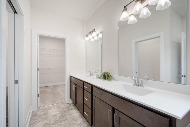 520 Meadow View Dr, Slinger, WI 53086 - full bath with double vanity, a spacious closet, and a chandelier