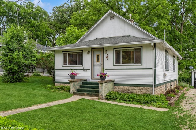 W3632 Oakrest Ave, Lake Geneva, WI 53147 - bungalow-style house with a front yard, a shingled roof, and view of wooded area
