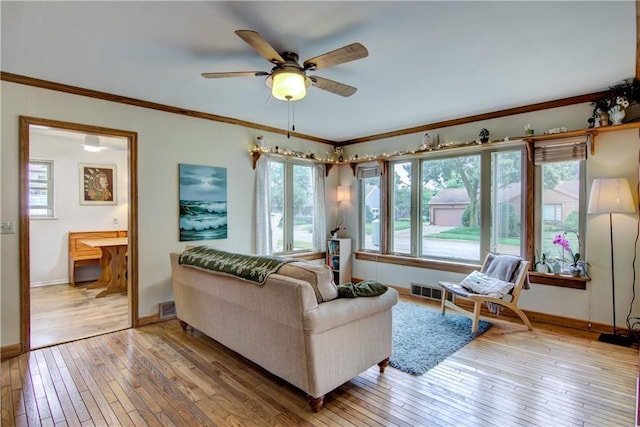 1418 Keith St, Eau Claire, WI 54701 - living area featuring light wood-style flooring, plenty of natural light, a ceiling fan, and ornamental molding