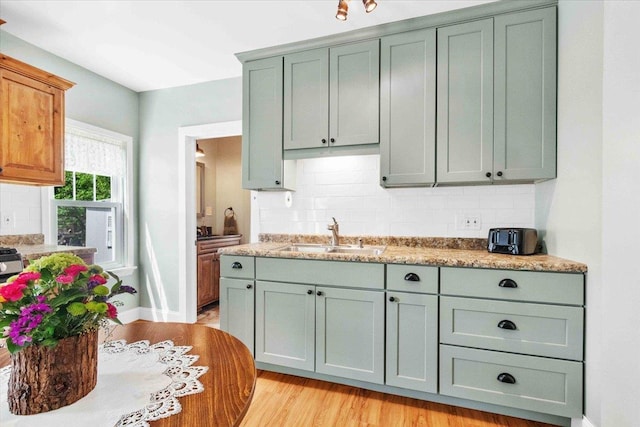 117 6th St, Nekoosa, WI 54457 - kitchen with backsplash, light wood finished floors, and light stone counters