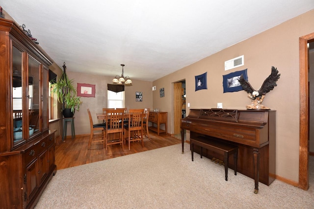 819 S 90th St, West Allis, WI 53214 - dining space with a chandelier, light wood-style flooring, and light colored carpet