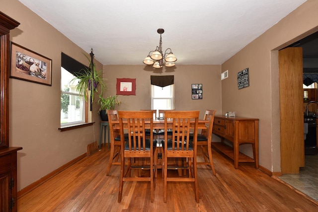 819 S 90th St, West Allis, WI 53214 - dining space with light wood finished floors and a chandelier
