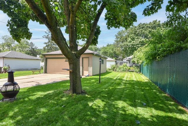 819 S 90th St, West Allis, WI 53214 - view of grassy yard featuring an outbuilding, a garage, and concrete driveway