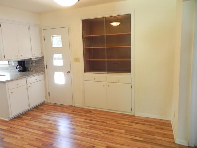 206 S High St, Port Washington, WI 53074 - kitchen featuring light wood finished floors, white cabinets, decorative backsplash, and light countertops