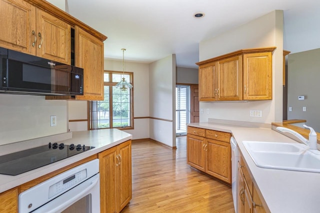 4431 Bellhaven Ln, Oshkosh, WI 54904 - kitchen featuring black appliances, light wood-style floors, light countertops, pendant lighting, and brown cabinets