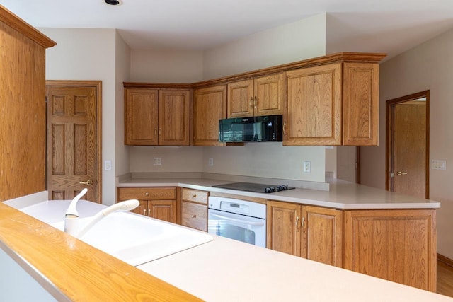 4431 Bellhaven Ln, Oshkosh, WI 54904 - kitchen with black appliances, light countertops, a peninsula, and brown cabinets