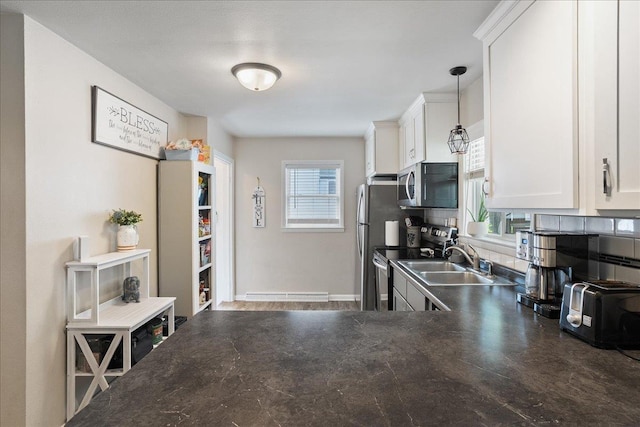 203 N Vine St, Marshfield, WI 54449 - kitchen with appliances with stainless steel finishes, dark countertops, healthy amount of natural light, and white cabinets