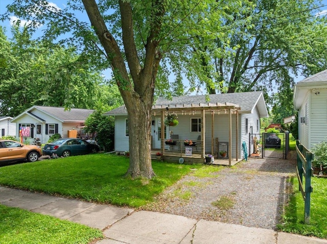 203 N Vine St, Marshfield, WI 54449 - view of front of house with a gate, a front yard, a pergola, gravel driveway, and roof with shingles