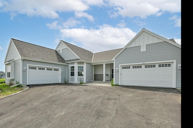 1382 Prairie Creek Cir Unit 15D, Oconomowoc, WI 53066 - view of front of property featuring a garage, board and batten siding, driveway, and roof with shingles