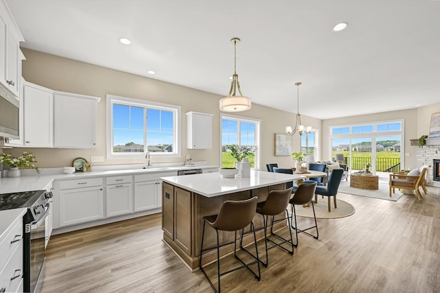 1382 Prairie Creek Cir Unit 15D, Oconomowoc, WI 53066 - kitchen featuring stainless steel appliances, a breakfast bar area, a chandelier, a kitchen island, and white cabinets