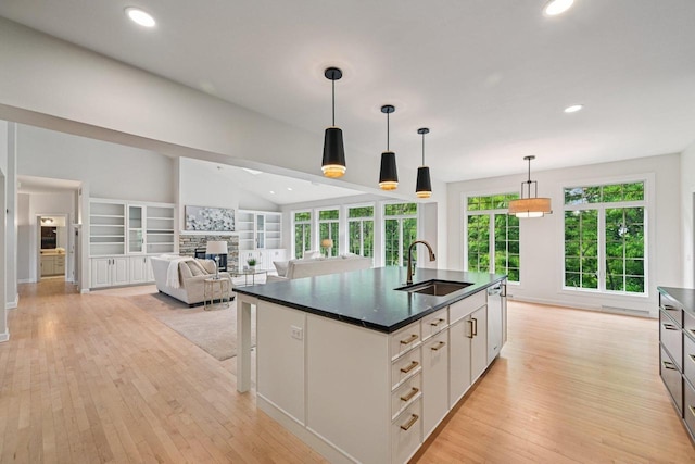1706 Ashlawn Ln, Waunakee, WI 53597 - kitchen featuring dark countertops, light wood-style flooring, a fireplace, plenty of natural light, and recessed lighting