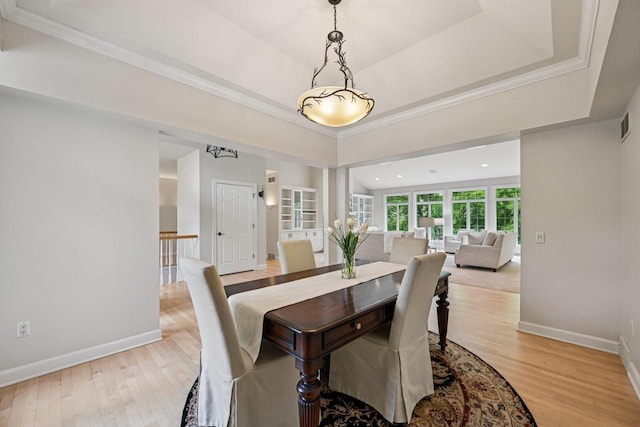 1706 Ashlawn Ln, Waunakee, WI 53597 - dining space featuring light wood-style flooring, crown molding, and a tray ceiling