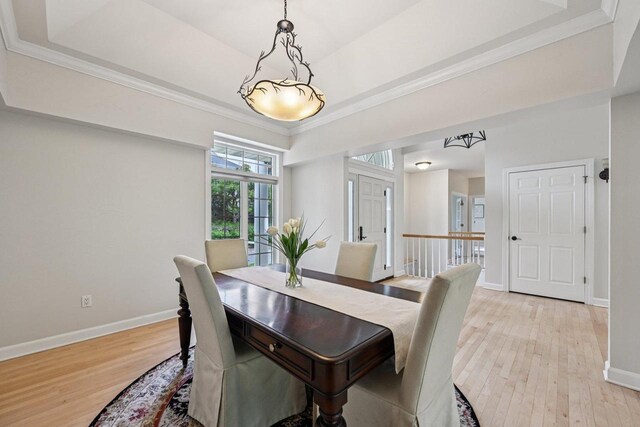 1706 Ashlawn Ln, Waunakee, WI 53597 - dining area with a raised ceiling, light wood finished floors, and ornamental molding
