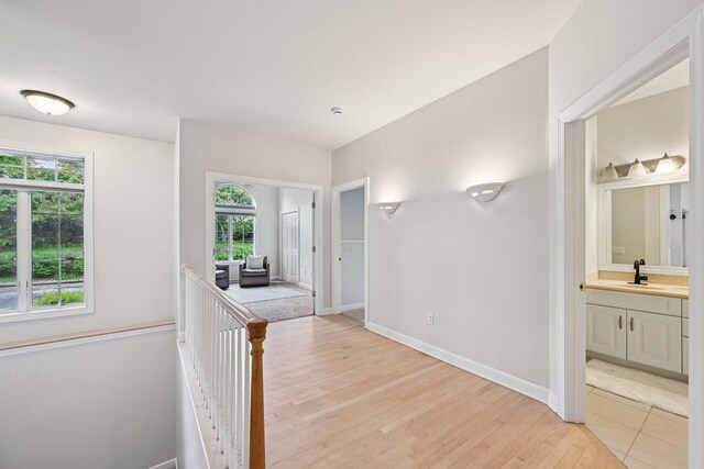 1706 Ashlawn Ln, Waunakee, WI 53597 - hall with light wood-style flooring and an upstairs landing