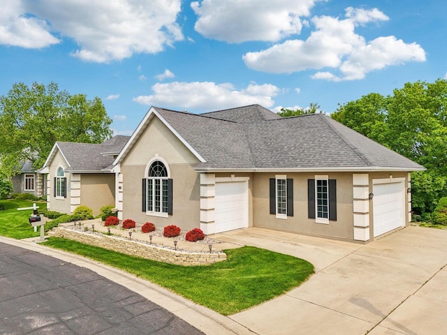 1706 Ashlawn Ln, Waunakee, WI 53597 - view of front of house with a garage, concrete driveway, stucco siding, a shingled roof, and a front lawn