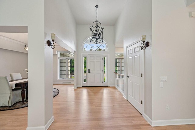 1706 Ashlawn Ln, Waunakee, WI 53597 - foyer with light wood finished floors, a high ceiling, and a chandelier