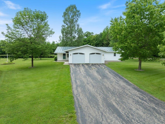 7269 County Road V, Marshfield, WI 54449 - view of front of property with an attached garage, asphalt driveway, a front lawn, and a standing seam roof