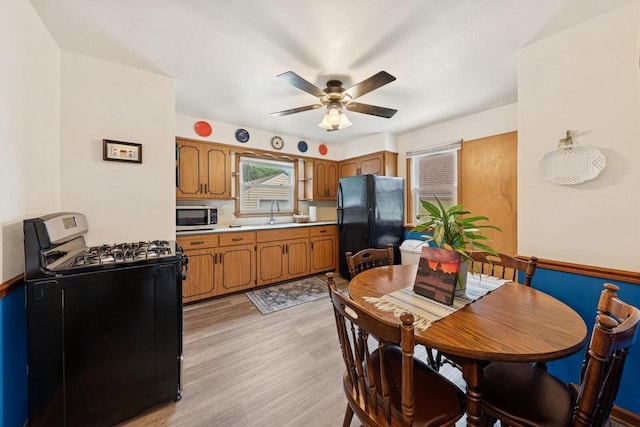 6109 38th Ave, Kenosha, WI 53142 - kitchen featuring black appliances, brown cabinetry, a ceiling fan, light countertops, and light wood finished floors
