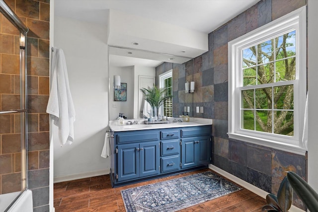 9848 N Lamplighter Ln, Mequon, WI 53092 - full bath featuring plenty of natural light, double vanity, wood finished floors, tile walls, and shower / bath combination with glass door