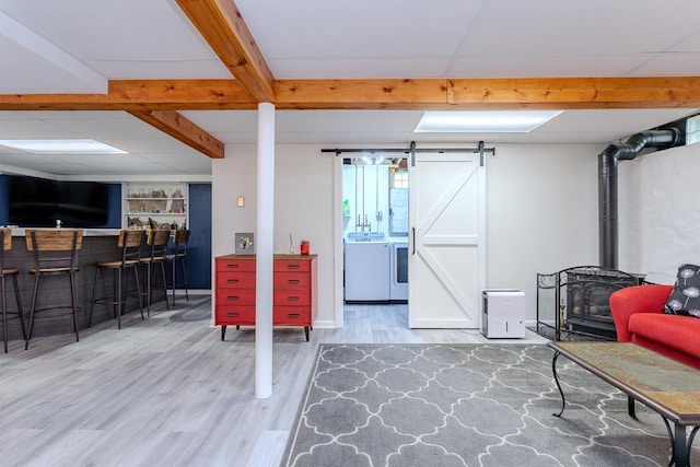 1119 W Grand Ave, Rothschild, WI 54474 - basement featuring washing machine and clothes dryer, wood finished floors, a wood stove, bar area, and built in features